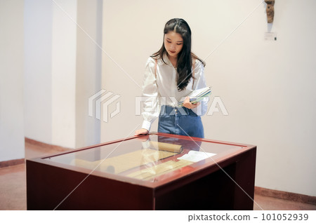 Young woman looking at artifacts Young woman looking at artifacts 101052939