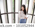Young pretty woman holding some notebooks and looking downward 101052944