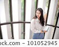 Young pretty woman holding some notebooks and looking aside 101052945