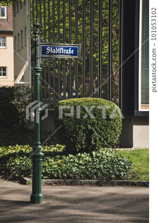 Vertical shot of the old green pole with a street sign in Freiburg im Breisgau, Germany. 101053102