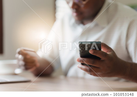 Young african american man using mobile cell phone hold credit bank card. banking application, online shopping concept Young african american man using mobile cell phone hold credit bank card. banking application, online shopping concept 101053148