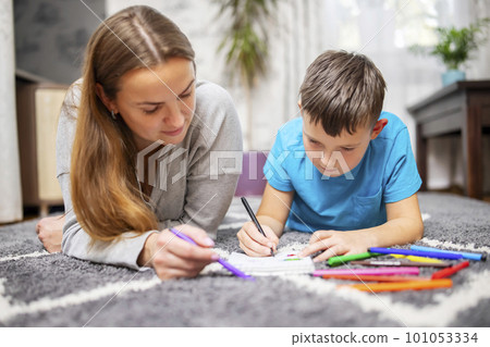 Happy family playing together on floor. Mother and son painting together Happy family playing together on floor. Mother and son painting together 101053334