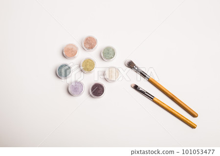 Many colorful natural mineral eyeshadows and make up brushes isolated on white background with copy space and empty space for text Many colorful natural mineral eyeshadows and make up brushes isolated on white background with copy space and empty space for text 101053477