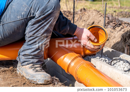 installation of a sewage plastic pipe during the construction of a house 101053673