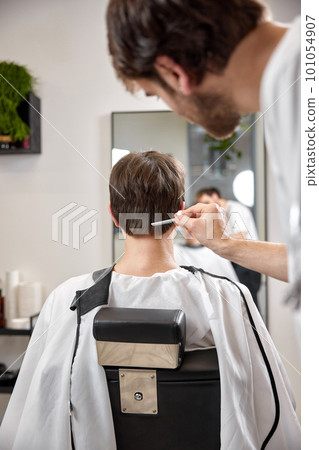 caucasian man getting haircut by professional male hairstylist caucasian man getting haircut by professional male hairstylist 101054907