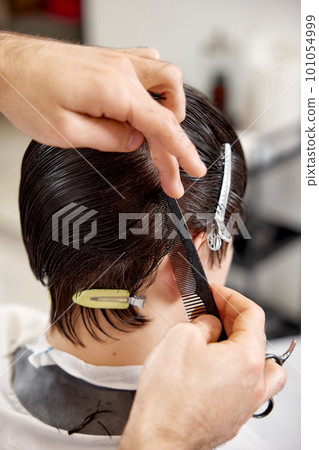 young caucasian man getting haircut by professional male hairstylist young caucasian man getting haircut by professional male hairstylist 101054999