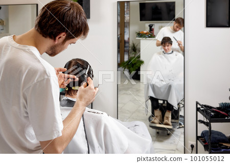 young caucasian man getting haircut by professional male hairstylist young caucasian man getting haircut by professional male hairstylist 101055012