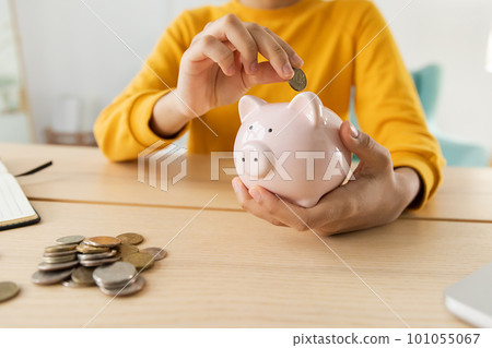 Saving money investment for future. African american girl holding pink piggy bank and putting money coin. Saving investment budget business wealth retirement financial money banking concept 101055067