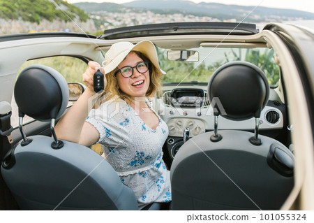 Young happy woman showing key of new car - Rental and buy new car concept Young happy woman showing key of new car - Rental and buy new car concept 101055324