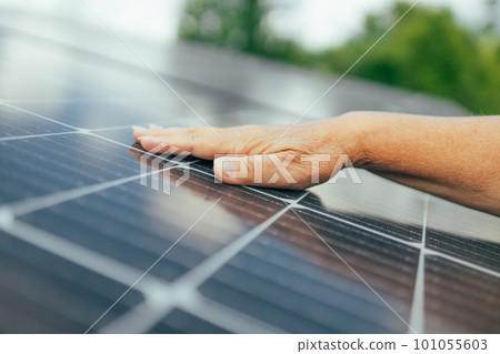 Close up of an young engineer hand is checking an operation of sun and cleanliness of photovoltaic solar panels on a sunset. Concept:renewable energy, technology,electricity,service, green,future 101055603