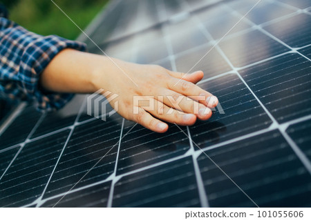 Close up of an young engineer hand is checking an operation of sun and cleanliness of photovoltaic solar panels on a sunset. Concept:renewable energy, technology,electricity,service, green,future 101055606