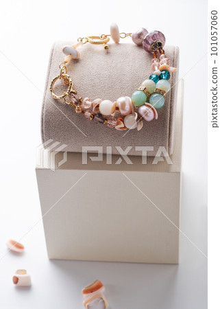 author gold plated bracelete with pearls and gemstones demonstrated against white background. fashion and jewelry concept author gold plated bracelete with pearls and gemstones demonstrated against white background. fashion and jewelry concept 101057060