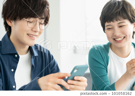 Young men and women using smartphones 101058162