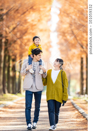 Parent and child walking with a shoulder car 101059332