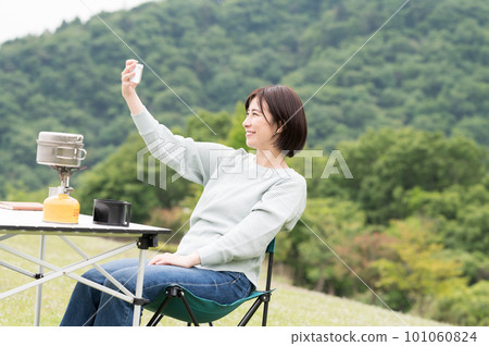 A woman taking a selfie at a solo camp A woman taking a selfie at a solo camp 101060824