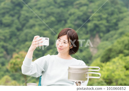 A woman taking a selfie at a solo camp A woman taking a selfie at a solo camp 101060852