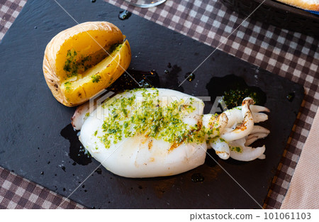 Nicely served cuttlefish grilled with garlic and parsley with potatoes on side Nicely served cuttlefish grilled with garlic and parsley with potatoes on side 101061103