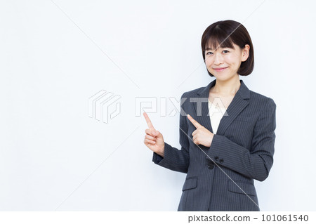 A business woman in her thirties wearing a suit pointing A business woman in her thirties wearing a suit pointing 101061540