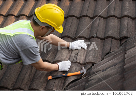 Worker man replace tile of the old roof. Repair roof concept. 101061762