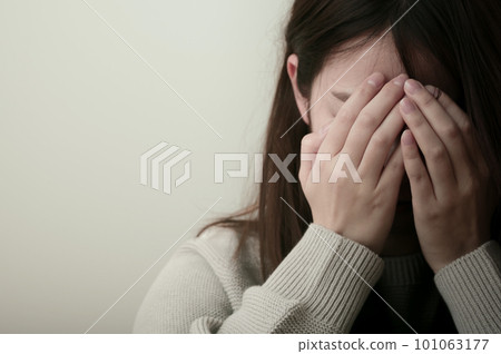 年輕女子痛苦地抱著頭 101063177