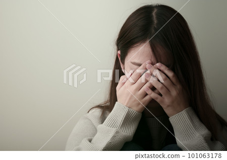 年輕女子痛苦地抱著頭 101063178