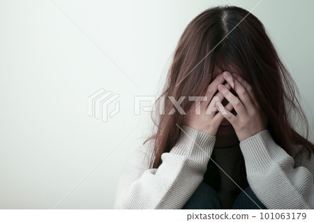 Young woman holding her head painfully 101063179