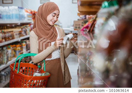beautiful Muslim girl checking shopping receipt when carrying basket 101063614