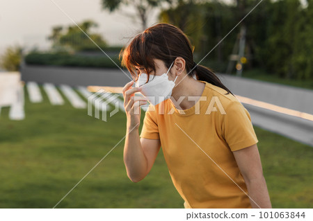 young Asian woman wearing N95 respiratory mask protect and filter pm2.5 or particulate matter against bad Air Pollution in City. Air Quality Index, AQI, Unhealthy, healthcare concept young Asian woman wearing N95 respiratory mask protect and filter pm2.5 or particulate matter against bad Air Pollution in City. Air Quality Index, AQI, Unhealthy, healthcare concept 101063844
