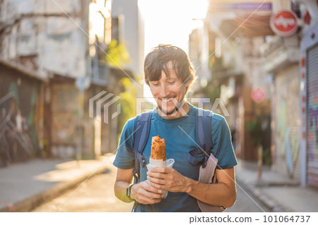 Man eating street food in Istanbul. Balik ekmek - fish in a bread, traditional Turkish fast food. Istanbul, Turkey 101064737