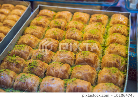 Traditional oriental sweet pastry cookies, nuts, dried fruits, pastilles, marmalade, Turkish desert with sugar, honey and pistachio, in display at a street food market 101064743