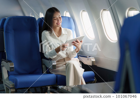 Beautiful Asian businesswoman working with digital tablet in aeroplane. working, travel, business concept 101067046