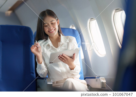 Beautiful Asian businesswoman working with digital tablet in aeroplane. working, travel, business concept 101067047