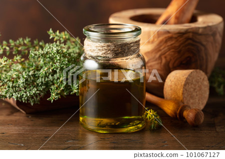 Bottle of thyme essential oil with fresh thyme. 101067127