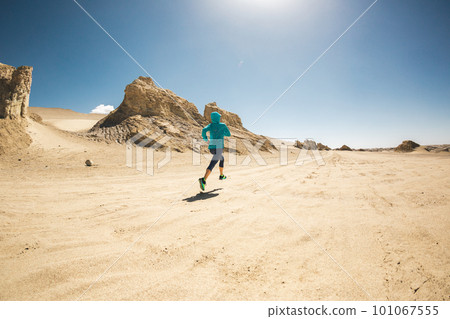 Fitness woman trail runner cross country running on sand desert 101067555