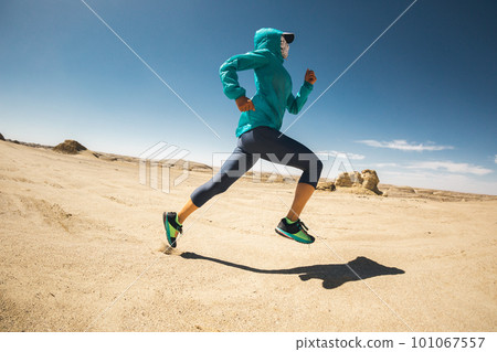 Fitness woman trail runner cross country running on sand desert 101067557