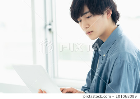 靠窗操作電腦的男人 101068099