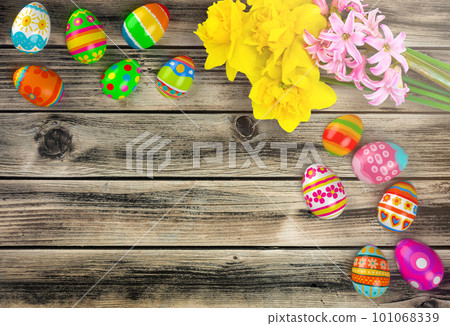 Colorful Easter eggs with yellow flowers on wooden background, flat lay. Space for text Colorful Easter eggs with yellow flowers on wooden background, flat lay. Space for text 101068339