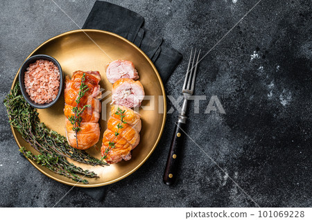 Roasted Stuffed chicken roll with cheese and ham on a steel plate. Dark background. Top view. Copy space 101069228