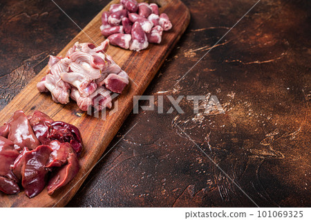 Raw chicken offals, liver, hearts, gizzards Stomach meat set. Dark background. Top view. Copy space 101069325