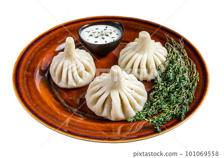 Khinkali Dumplings with beef and lamb meat on rustic plate with herbs. Isolated on white background Khinkali Dumplings with beef and lamb meat on rustic plate with herbs. Isolated on white background 101069558