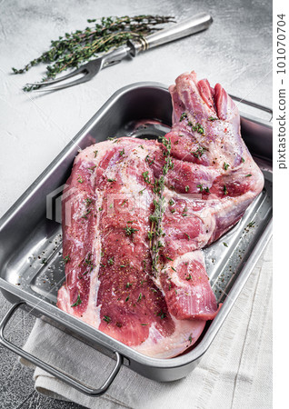 Ready for cooking lamb whole shoulder, raw leg meat on a grill pan with spices. Black background. Top view. Copy space. Ready for cooking lamb whole shoulder, raw leg meat on a grill pan with spices. Black background. Top view. Copy space. 101070704