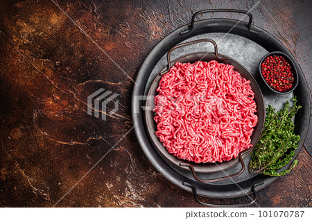 Raw Mince, minced Ground beef meat in a kitchen tray. Dark background. Top view. Copy space Raw Mince, minced Ground beef meat in a kitchen tray. Dark background. Top view. Copy space 101070787