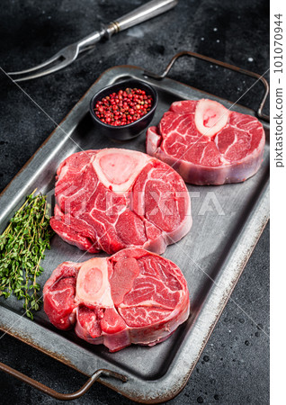 Fresh Raw Osso buco Veal steak, cross cut veal shank Ossobuco. Black background. Top view 101070944