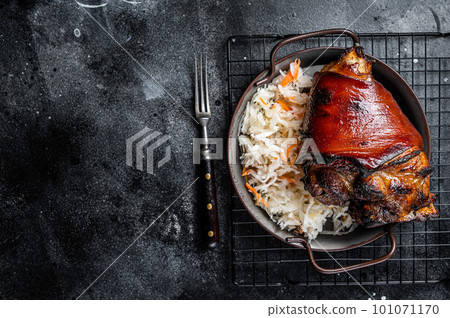 Traditional German cuisine Roasted pork knuckle Schweinshaxe with Sauerkraut. Black background. Top view. Copy space 101071170