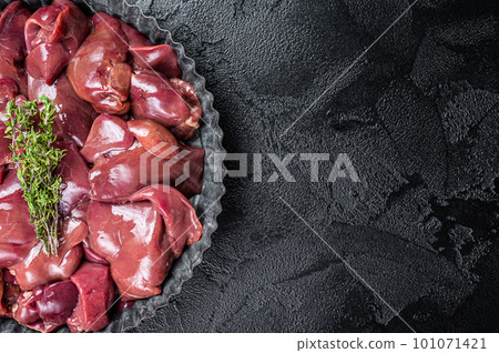 Uncooked Raw chicken liver, poultry offals in steel plate. Black background. Top view. Copy space 101071421
