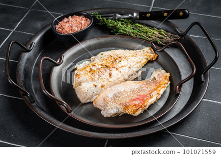 Roasted ocean red perch fillet with olive oil, thyme and spices. Black background. Top view 101071559