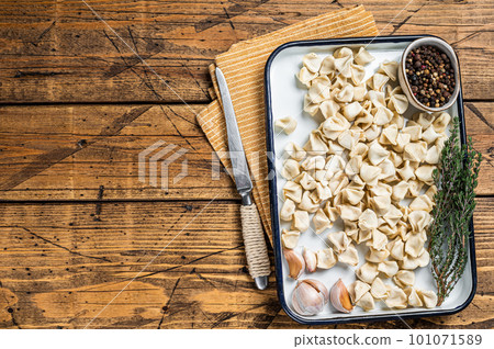 Raw Manti Dumpling with meat in tray with herbs and spices. Wooden background. Top view. Copy space 101071589