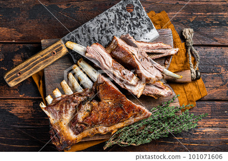 Roast lamb ribs, mutton spareribs, sliced meat on wooden board. Wooden background. Top view Roast lamb ribs, mutton spareribs, sliced meat on wooden board. Wooden background. Top view 101071606