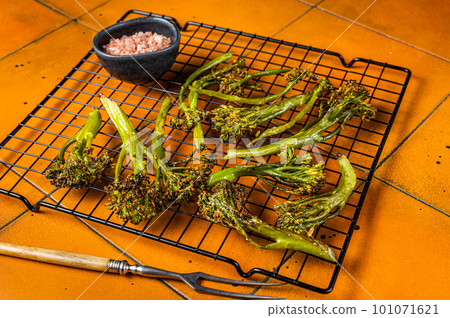 Grilled Broccolini Sprouts with garlic. Orange background. Top view 101071621
