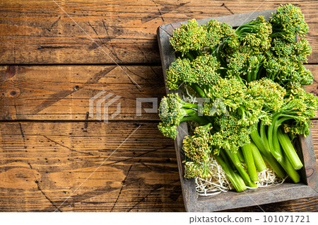 Raw Organic Fresh Broccolini Vegetable in a wooden box. Wooden background. Top view. Copy space Raw Organic Fresh Broccolini Vegetable in a wooden box. Wooden background. Top view. Copy space 101071721